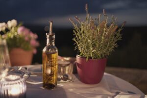 clear glass bottle of extra virgin olive oilbeside plant